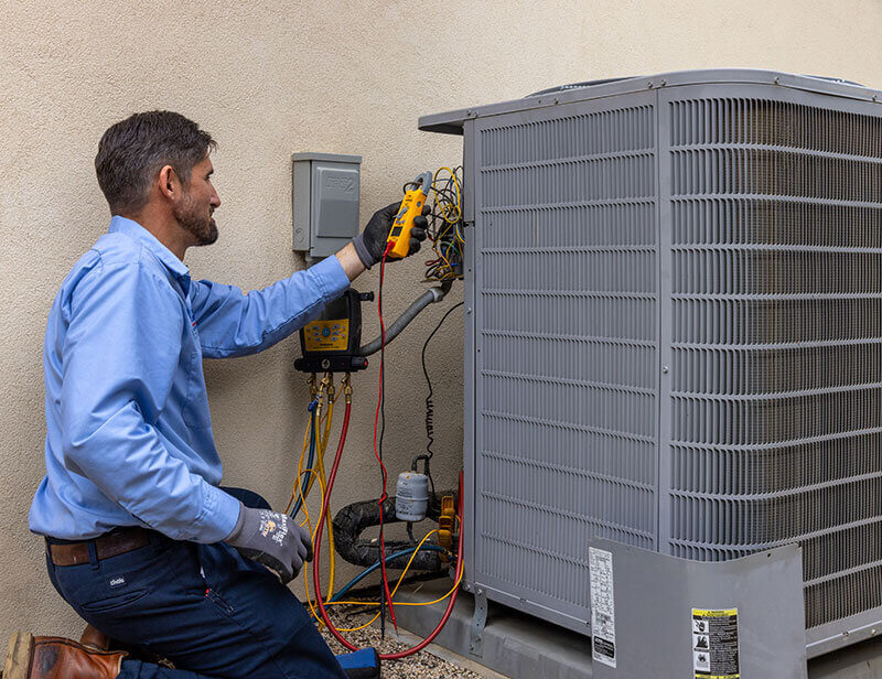 Technician diagnosing a heating system with gauge manifold and meter, safety testing and airflow checks in Ypsilanti. Call (734) 999-7310. Call (734) 999-7310 for Ypsilanti, MI.